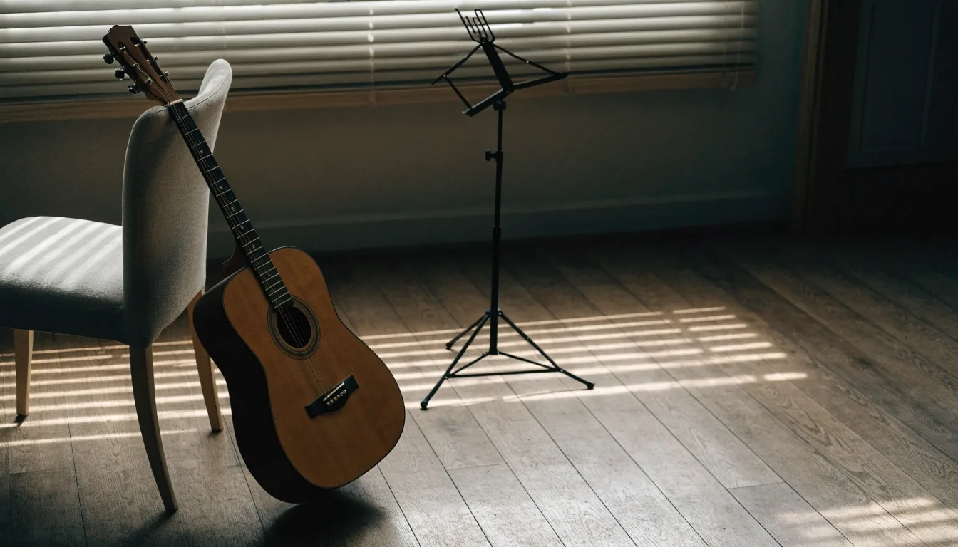 Acoustic guitar leaning on a chair in a small teaching room with light across the floor
